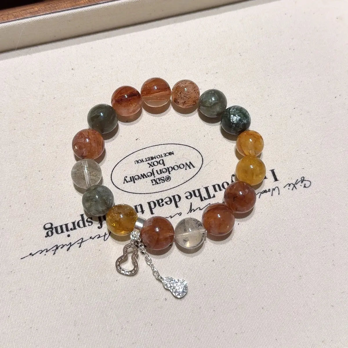 Handcrafted yellow-hematoid-quartz; red-hematoid-quartz; green-phantom-quartz; seraphinite; black-gold-super-seven; emerald Detail for Abundance - Astara